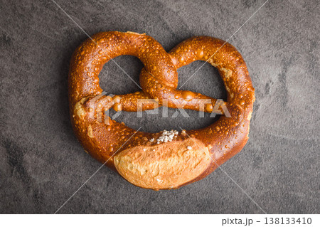 Soft Salted Pretzel On Dark Background. Fresh Baked German Snack From Artisan Bakery Soft Salted Pretzel On Dark Background. Fresh Baked German Snack From Artisan Bakery 138133410