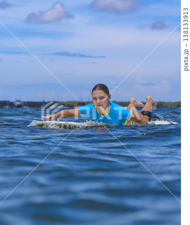 Portrait of female Surfer Paddling With Concentration And Strength 138133913