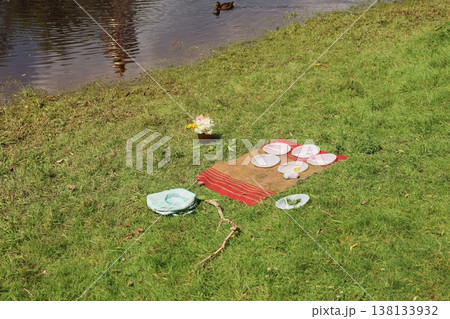 Gentle ripples reflect quiet lakeside picnic setting with plates Gentle ripples reflect quiet lakeside picnic setting with plates 138133932
