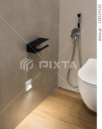 Minimalist modern bathroom corner with toilet and bidet sprayer Minimalist modern bathroom corner with toilet and bidet sprayer 138134120