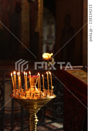 Faint candle flames in church evoke serene reflective mood 138134213