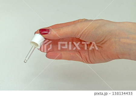 Female hand holding pipette dropper 138134433
