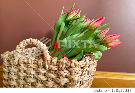 Red tulips in a basket close-up. A gift for a girl for the holidays. High quality photo Red tulips in a basket close-up. A gift for a girl for the holidays. High quality photo 138135337