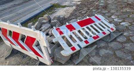 Road paving slabs piled up and cordoned off with warning signs. Road construction and repair in urban conditions. High quality photo 138135339