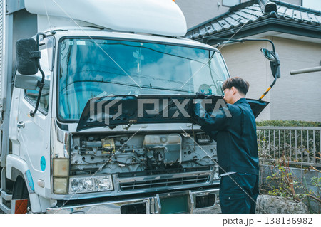 大型トラックのフロントパネルを開けて始業点検をするトラックドライバー 大型トラックのフロントパネルを開けて始業点検をするトラックドライバー 138136982