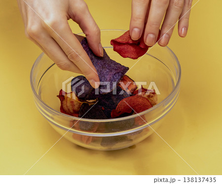 Female hands holding colorful potato chips 138137435