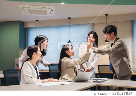 オフィスで大喜びをしてハイタッチをする女性 オフィスで大喜びをしてハイタッチをする女性 138137814