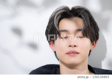 日射しの強い若い男性のお洒落な美容や爽やかで透明感のあるメンズビューティーイメージ目を閉じる 138138903