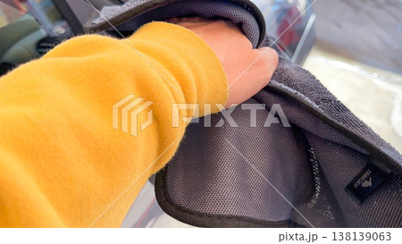 Man wiping and drying car with grey microfiber rag outdoors, closeup Man wiping and drying car with grey microfiber rag outdoors, closeup 138139063