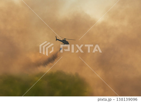 Fire fighting helicopter carry watethar bucket to extinguish the forest fire. 138139096