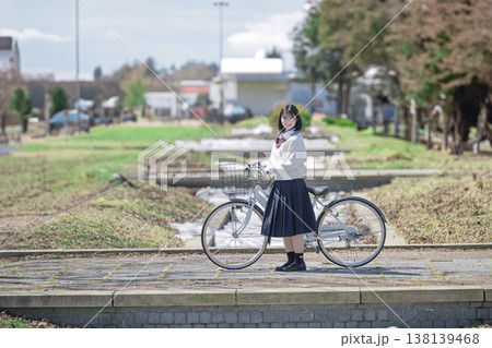 自転車を押して立つ女子学生 138139468