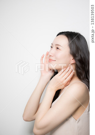 黒髪が綺麗で白背景の若い女性の艶や透明感のあるビューティーイメージ 横顔で見上げる 黒髪が綺麗で白背景の若い女性の艶や透明感のあるビューティーイメージ 横顔で見上げる 138139503