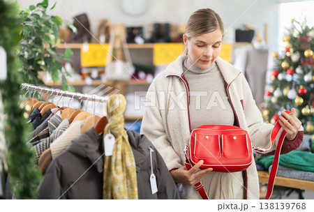 Adult woman choosing handbag in clothing store Adult woman choosing handbag in clothing store 138139768