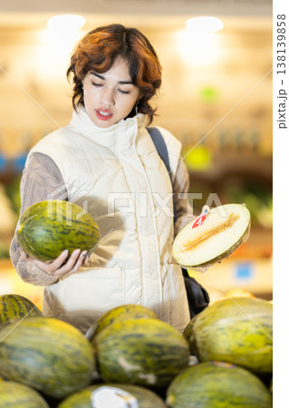 Young woman chooses melon in store Young woman chooses melon in store 138139858