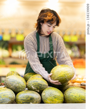 Seller in grocery vegetable shop arrange melon. Seller in grocery vegetable shop arrange melon. 138139909