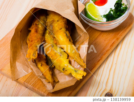 Fish and chips with creamy cheese sauce 138139959