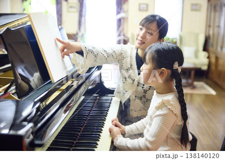 ピアノ教室でレッスンを行う先生と生徒の女の子 ピアノ教室でレッスンを行う先生と生徒の女の子 138140120
