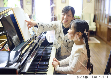 ピアノ教室でレッスンを行う先生と生徒の女の子 ピアノ教室でレッスンを行う先生と生徒の女の子 138140121