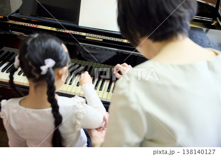 上から見たシニア講師と女の子のピアノ個人レッスン 上から見たシニア講師と女の子のピアノ個人レッスン 138140127
