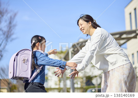 学校帰りの娘へ手を伸ばして迎える笑顔の母親 学校帰りの娘へ手を伸ばして迎える笑顔の母親 138140169