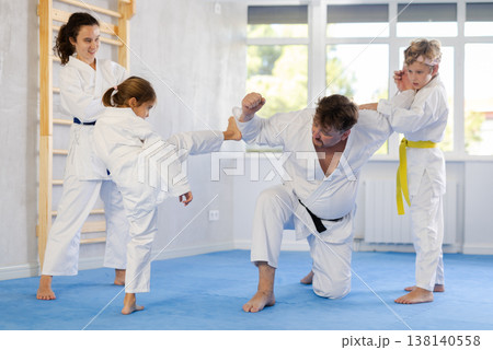 Family with children training karate fighting techniques 138140558