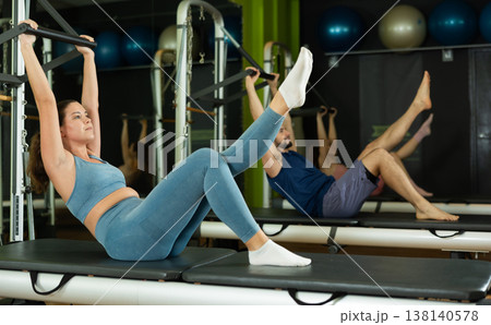 Young woman doing teaser exercise on pilates reformer Young woman doing teaser exercise on pilates reformer 138140578