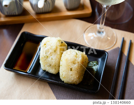 Fresh Japanese triangular onigiri with rice at black plate 138140660