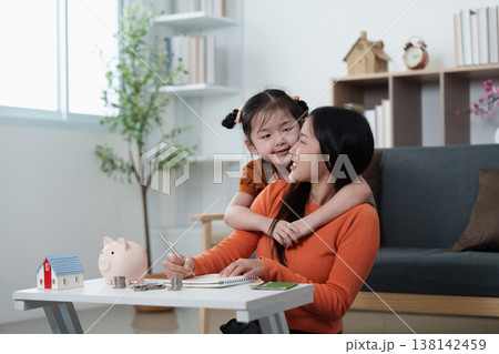 Mother teaching child financial literacy at home 138142459