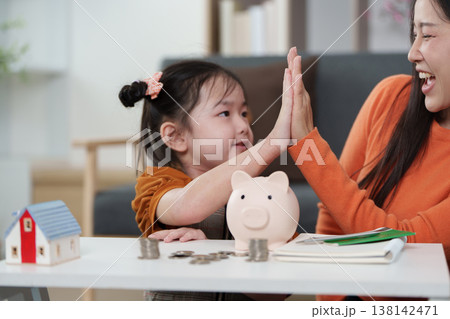 Mother and daughter celebrating financial learning success Mother and daughter celebrating financial learning success 138142471