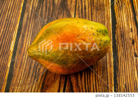 Ripe tropical papaya fruit with yellow and orange skin on a textured background. Ripe tropical papaya fruit with yellow and orange skin on a textured background. 138142553