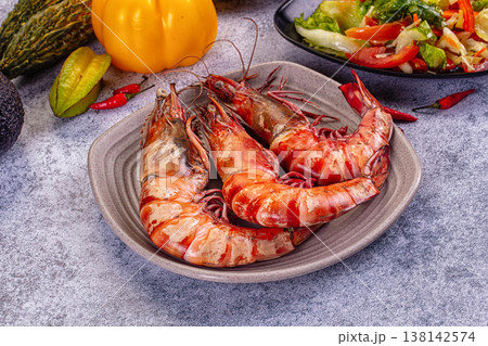 Grilled giant red prawns in a pan with fresh avocado, bell pepper, and salad on a stone table Grilled giant red prawns in a pan with fresh avocado, bell pepper, and salad on a stone table 138142574