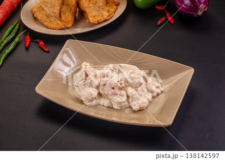Gourmet creamy shrimp appetizer in a modern gray bowl with chili peppers on a dark background. Gourmet creamy shrimp appetizer in a modern gray bowl with chili peppers on a dark background. 138142597