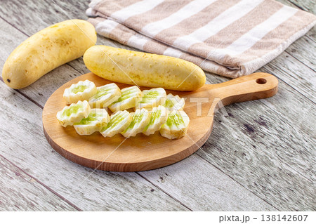 Freshly Sliced Yellow Cucumbers on a Wooden Cutting Board Freshly Sliced Yellow Cucumbers on a Wooden Cutting Board 138142607