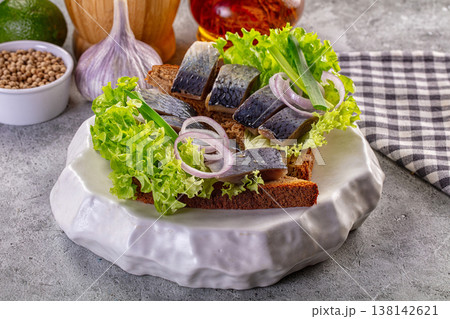 Traditional pickled herring sandwich on rye bread with lettuce and red onion Traditional pickled herring sandwich on rye bread with lettuce and red onion 138142621
