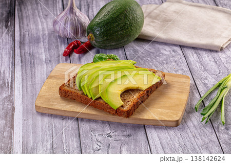 Fresh avocado toast on rye bread with whole ingredients on a rustic wooden table 138142624