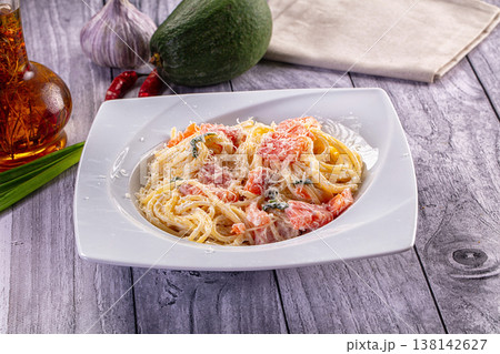 Creamy spaghetti pasta with salmon and grated parmesan cheese on a rustic wooden table. Creamy spaghetti pasta with salmon and grated parmesan cheese on a rustic wooden table. 138142627