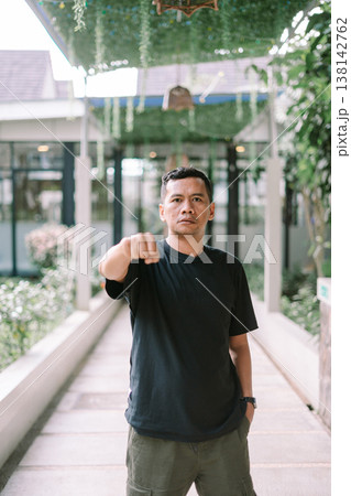 Angry man showing aggressive expression with hands on head in outdoor setting Angry man showing aggressive expression with hands on head in outdoor setting 138142762
