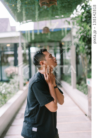 Young man suffering from neck pain touching neck with discomfort Young man suffering from neck pain touching neck with discomfort 138142818