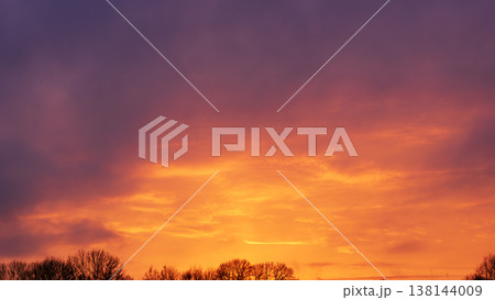 Beautiful sunset sky with vibrant orange glow and purple clouds 138144009
