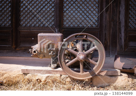 Rusty vintage industrial machine with wheel in front of traditional Korean house 138144099