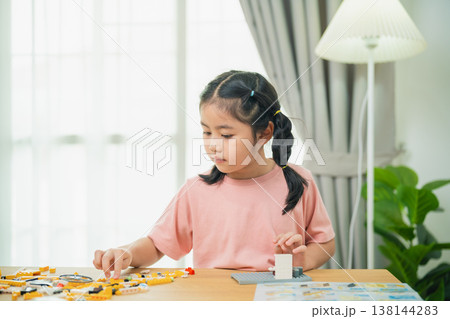 Young girl engaged in creative building with colorful construction blocks in a bright indoor space, focusing on playful learning and development Young girl engaged in creative building with colorful construction blocks in a bright indoor space, focusing on playful learning and development 138144283