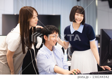 パソコンを見て話し合いをする男女 138144342