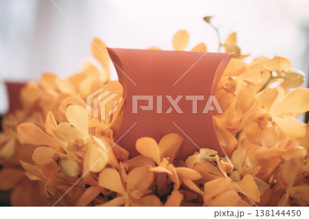 Close-up Wedding Favor Box Mockup in Orange Orchid Flowers 138144450