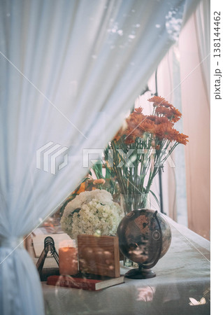 Elegant Wedding Table Decor with Vintage Globe, Flowers, and Soft Curtain Overlay Elegant Wedding Table Decor with Vintage Globe, Flowers, and Soft Curtain Overlay 138144462