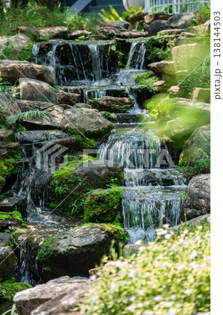 Beautiful Tiered Artificial Waterfall in a Lush Green Garden 138144503