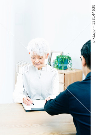 営業マンの説明を聞くシニア女性 138144639