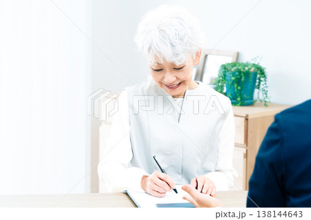 営業マンの説明を聞くシニア女性 138144643