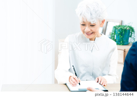 営業マンの説明を聞くシニア女性 138144644
