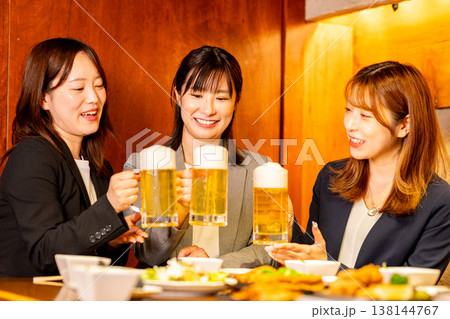 居酒屋で乾杯する若い女性 138144767