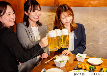 居酒屋で乾杯する若い女性 138144768